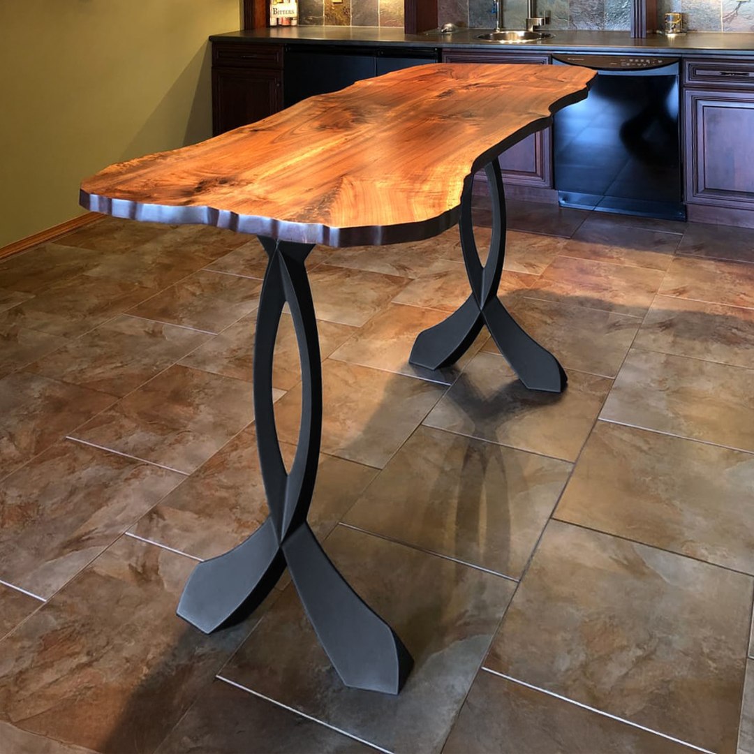Close-up of metal leg for counter table 607 Curva 40.3" H installed under live edge wood tabletop in modern interior.