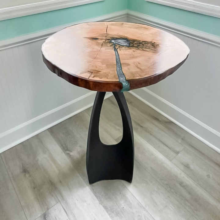 Counter height table placed near a window, showcasing artistic counter metal table base and solid wood top.