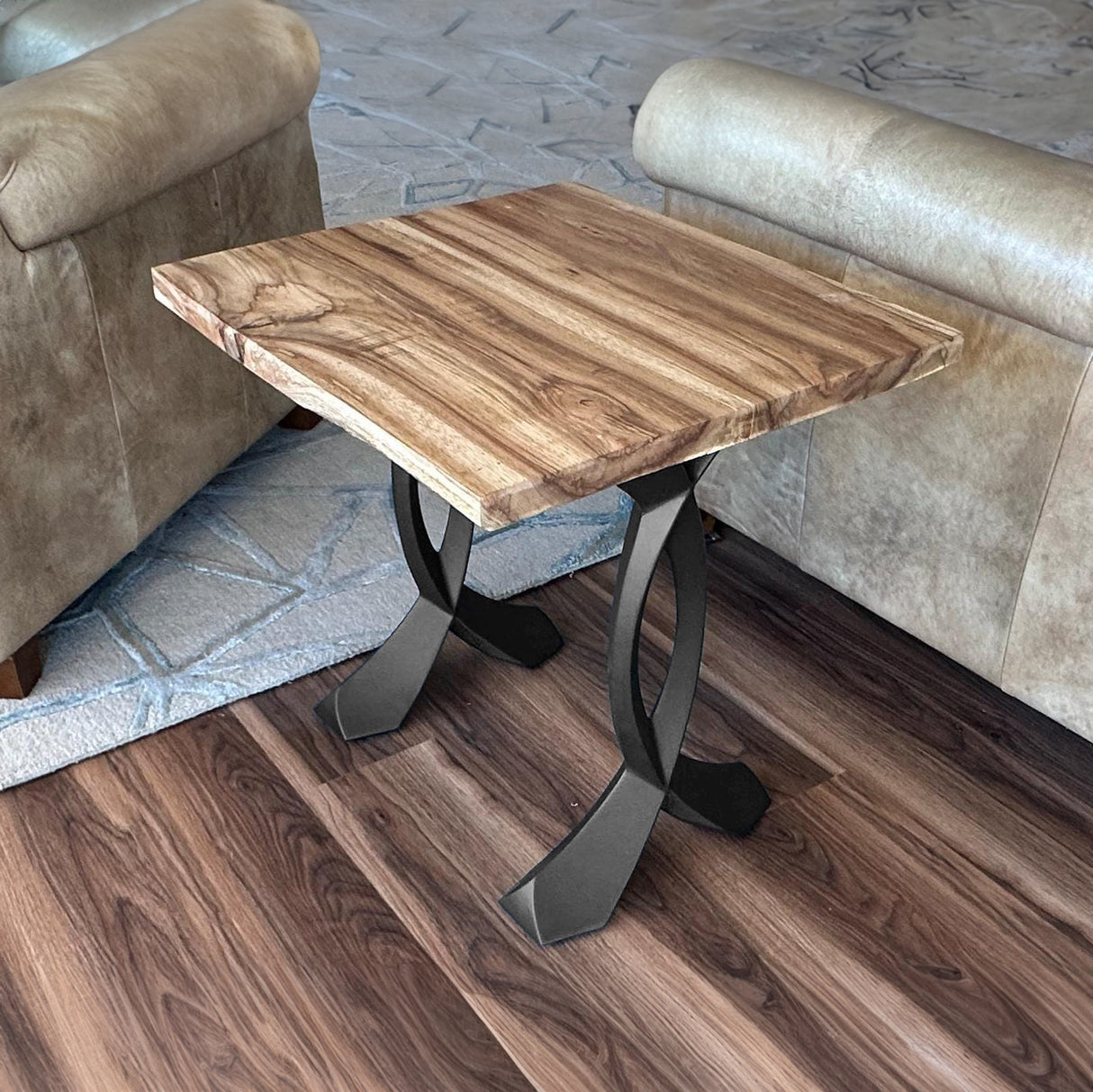 Modern end table with curved design end table legs metal supporting a striped wooden top.