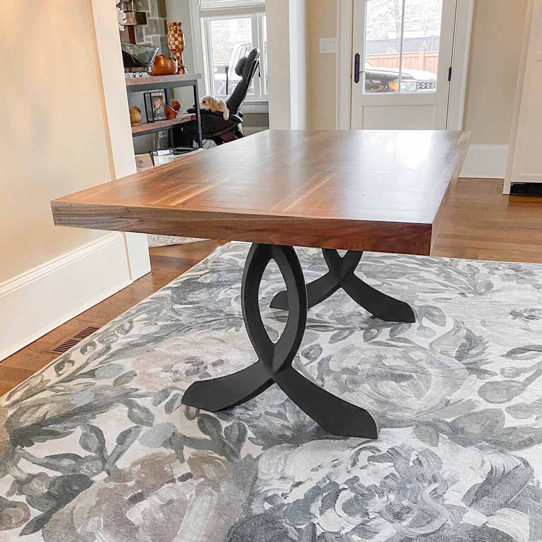 Rustic dining table with curved metal legs for table in cozy indoor environment.