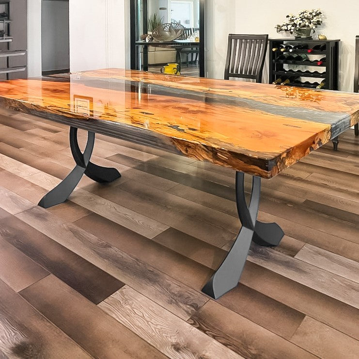 Live-edge wood table with black curved design table legs metal on patio.