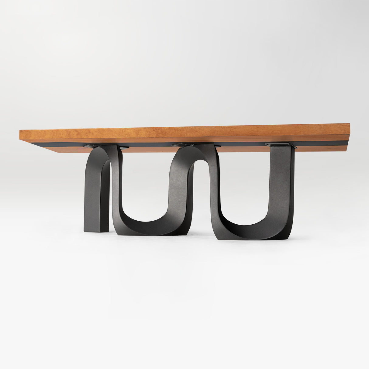 Modern U-shaped metal table base with wooden tabletop on white background