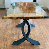 Forest-edge outdoor table supported by curved design table legs metal.