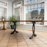 Live-edge dining table supported by 423 Curva 28" H curved design metal table legs in a bright sunroom.